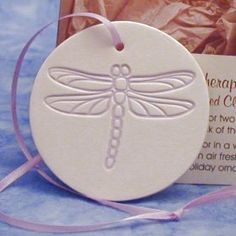 an ornament with a dragonfly on it next to a package of chocolates