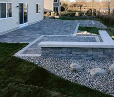 an outdoor patio area with rocks and grass