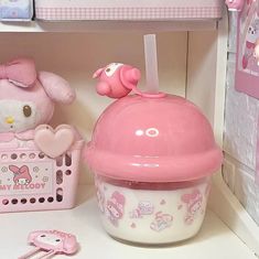 a hello kitty doll house with pink accessories and items on the counter top in front of it