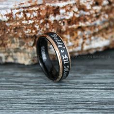 a black and gold ring with words engraved on it