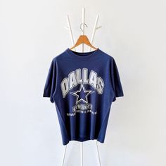 90s Dallas Cowboys NFL t-shirt/ L * PLEASE READ BEFORE PURCHASE * PLEASE consider the PHOTOS before making the decision * The images may DIFFER in appearance from the actual product because we took pictures under daylight.  * PLEASE send your PHONE NUMBER after your purchase for the shipping company to contact you X No returns X No refund Condition : 8/10 More details : look at the pictures  Brand :  Size : L Pit to pit/ Chests : 22/44 inches  Length : 28 inches  Material : cotton  Color : blue * ALL ITEMS are VINTAGE which may show some signs of wear and tear * Due to the different display and different light, the picture may not reflect the actual color of the item * Please, remember that our items are vintage so they may show some signs of wear, tear and yellow stains. Thank you RE/11/1 Vintage Dallas Cowboys Shirt, 90s Inspired Blue T-shirt With Letter Print, 90s Inspired Short Sleeve T-shirt For Fans, 90s Style College T-shirt With Screen Print, 90s Blue T-shirt For College, 90s Style Blue T-shirt For College, 90s Style Crew Neck T-shirt For College, 90s Blue T-shirt With Text Print, 90s Style Short Sleeve College T-shirt