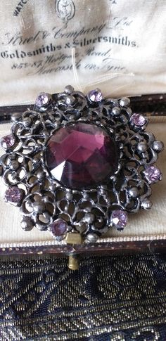 Antique Vintage Victorian 1890-s Pewter Brooch with Purple Stones-Rare Item! Pretty, blackened Pewter ornate openwork framed brooch with central faceted deep purple glass stone which is foiled back and little lilac rhinestones. A little rough looking in style but good for its age. Clasp:       Roll over locking clasp and pin in tact. SIZE: Approx: 4.5 cm x 4.5 cm   Good condition as shown BOX NOT INCLUDED IN SALE. FREE WORLDWIDE POSTAGE Purple Stones, Lovely Ring, Vintage Victorian, Purple Glass, Deep Purple, Antique Vintage, Antique Jewelry, Brooches, Lilac