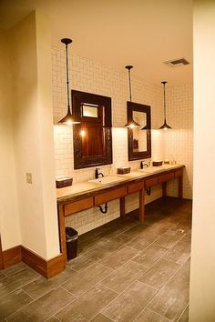 a bathroom with two sinks and three mirrors