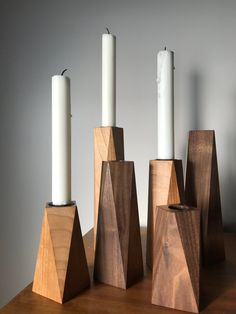 wooden candlestick holders with white candles in them