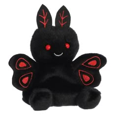 a black stuffed animal with red eyes and wings