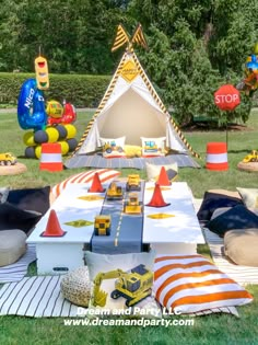 an outdoor party with construction themed decorations and balloons in the shape of cars, trucks and cones