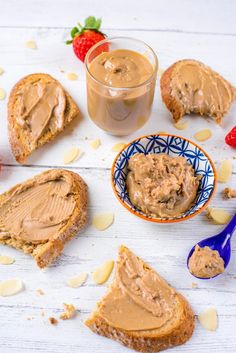 peanut butter and jelly sandwiches on a white wooden table with strawberries next to it