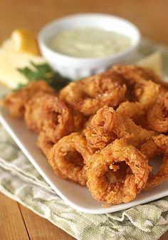 fried onion rings on a plate with dipping sauce