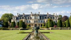 a large house with a fountain in front of it