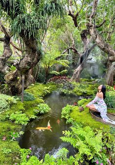 a woman is sitting on a bench in the middle of a pond surrounded by trees and plants