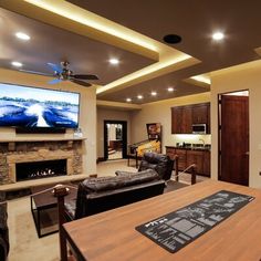 a living room filled with furniture and a flat screen tv mounted on the wall above a fireplace