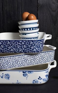 blue and white dishes stacked on top of each other with an egg in the middle