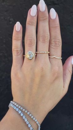 a woman's hand with three bracelets and a ring on her left wrist