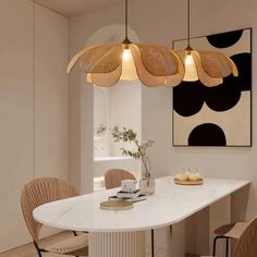 a dining room table with chairs and lights hanging from it's ceiling over it