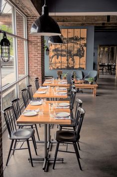 an empty restaurant with wooden tables and chairs