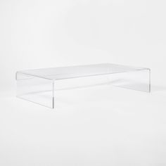 an acrylic coffee table is shown against a white background in this image, there are no people around it