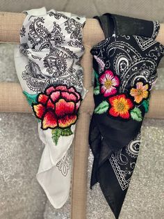 two scarves with flowers on them sitting on a chair