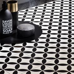 a black and white tiled floor with two bottles on it