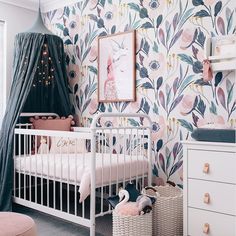 a baby's room with floral wallpaper and white crib