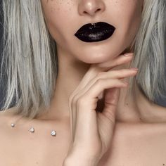 a woman with white hair and black lipstick on her face is posing for the camera