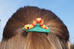 a close up of a woman's head with a hair clip in the shape of a snake