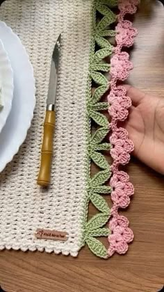 a crocheted placemat with a knife and fork on it next to a plate