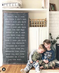 two young boys sitting on the floor in front of a chalkboard that says when i say i love you, i don't just mean i love you more