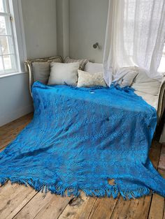 a bed with a blue blanket on top of it