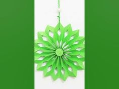 a green paper flower hanging from a string