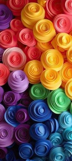 many different colors of rolled paper are arranged in the shape of spirals on top of each other