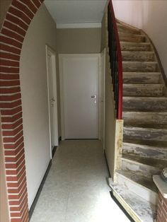 an empty hallway with stairs leading up to the door