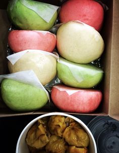 an open box filled with apples next to a bowl of food