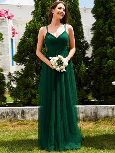 a woman in a long green dress holding a bouquet