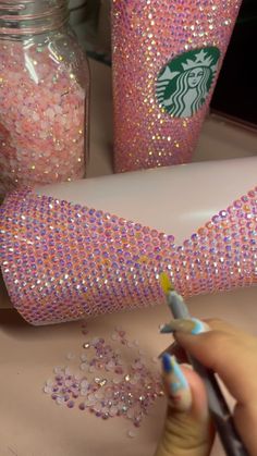 someone is painting the side of a cup with glitter