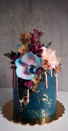 a blue cake with pink flowers on top