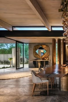 a dining room with a large wooden table and chandelier hanging from the ceiling