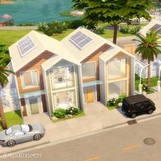 an aerial view of a house with cars parked on the street and palm trees in front of it