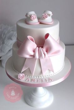 a white cake with pink bows on top