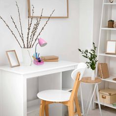 a white desk topped with a wooden chair next to a book shelf filled with books