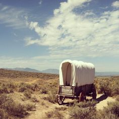 an old covered wagon in the desert on a sunny day