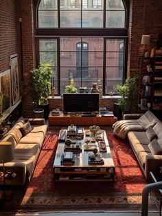 a living room filled with lots of furniture and large windows over the top of it