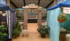 an indoor garden show with blue tarps and potted plants on the side walk