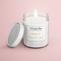 a candle that is sitting next to a container on a pink background with the words amber and patchoui written below it