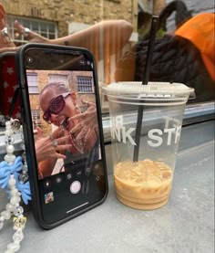 a cell phone sitting next to a plastic cup