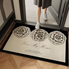 a woman standing in front of a door with her feet on the mat that says love my mom