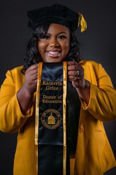 a woman wearing a yellow graduation gown and holding up her cap with the words keteria grice on it