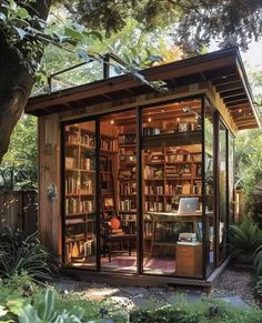 a small wooden building with lots of books on it's shelves in the yard