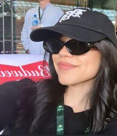 a woman wearing sunglasses and a baseball cap