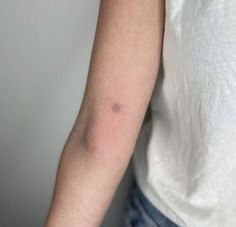 a woman's arm with a small tattoo on the left side of her arm