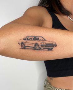 a woman's arm with a tattoo of a car on the back of it